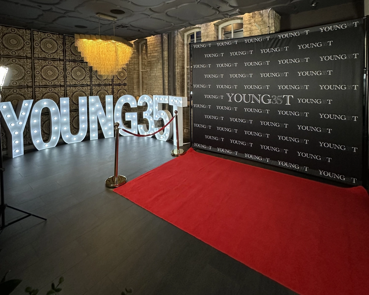 Custom step-and-repeat backdrop with light-up marquee letters and a red carpet at an event: custom photo booth backdrop rental in Brampton