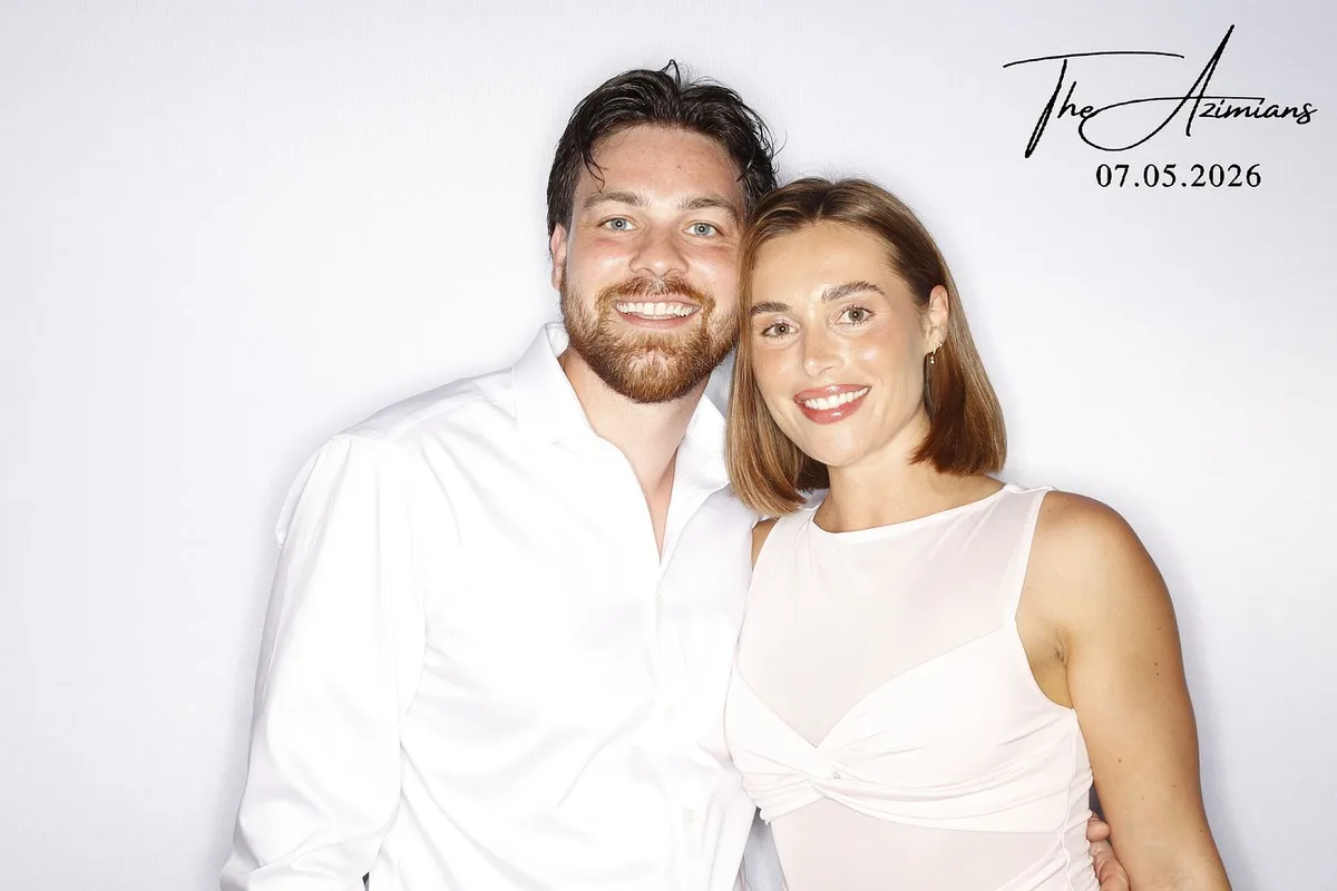 Couple at a glam photo booth against a white backdrop with a custom wedding print overlay: glam photo booth rental in Brampton