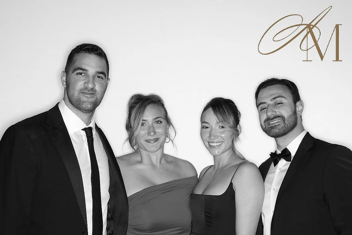 Four guests in formal wear at a glam photo booth, black-and-white finish: glam photo booth rental in Burlington