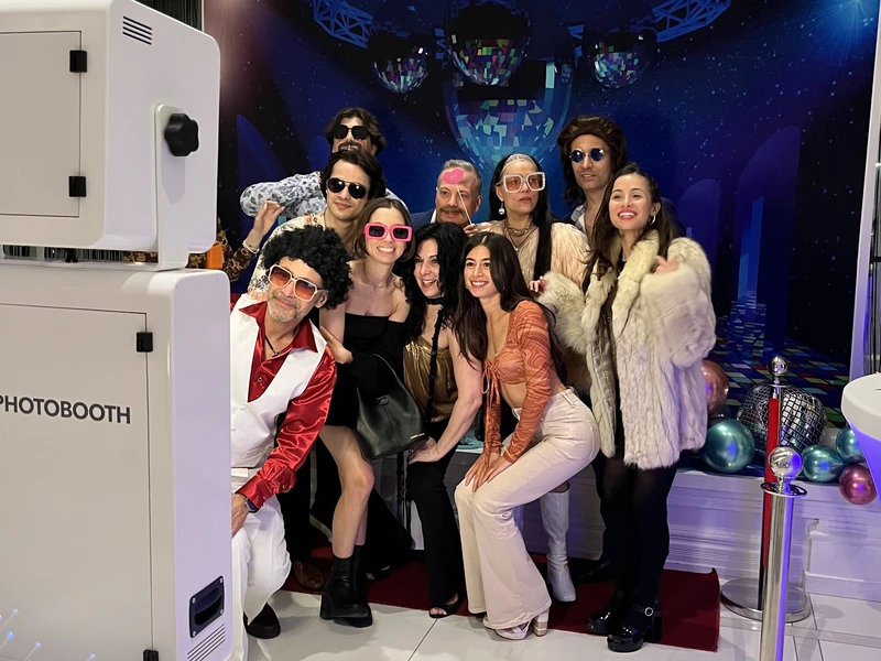 Group posing for an instant photo booth at an event: instant photo booth rental in Burlington