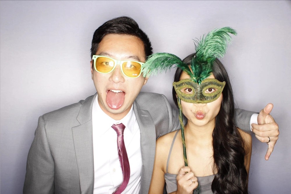 Couple posing with photo booth props: photo booth rental in Hamilton