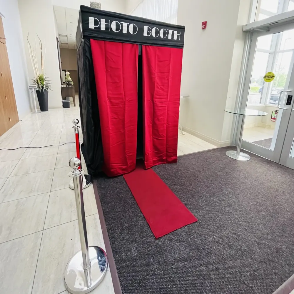 Red-curtained private photo booth on a red carpet in a bright venue lobby: private photo booth rental in Mississauga