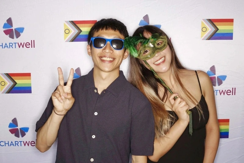 People posing in front of a custom backdrop at an event: custom photo booth backdrop rental in Oakville