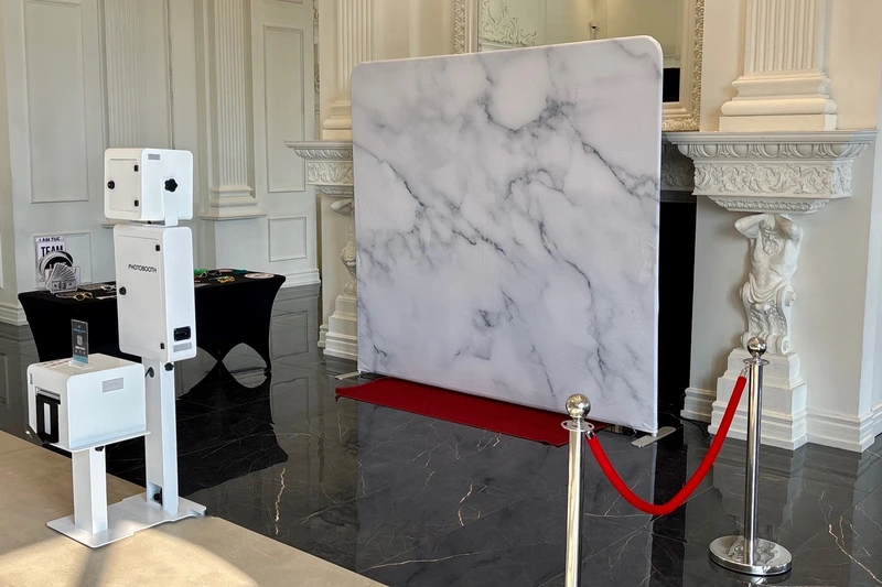 Instant photo booth beside a white marble backdrop and red carpet in a ballroom: instant photo booth rental in Vaughan