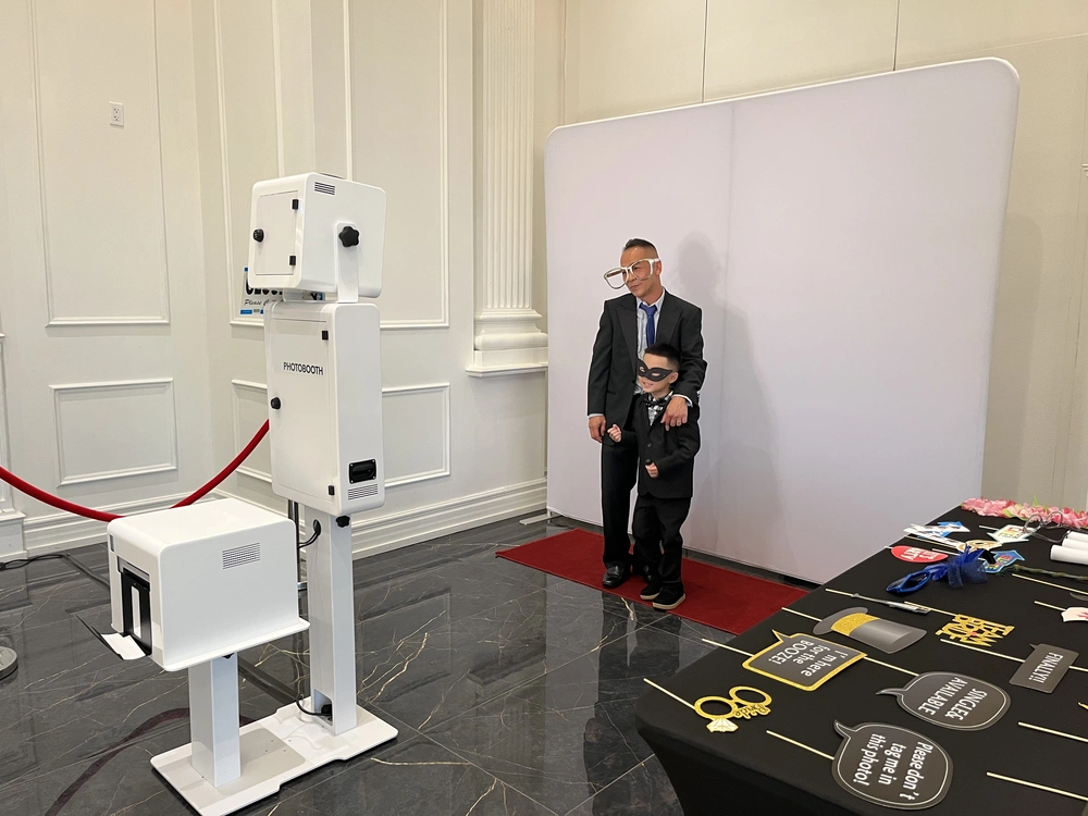 Toronto Snaps photo booth set up with a white backdrop, red carpet and props table: photo booth rental in Vaughan