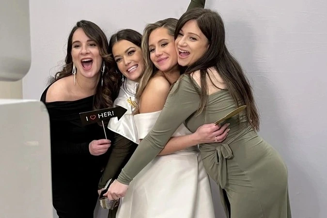 Group of women posing for a picture with a wedding photobooth