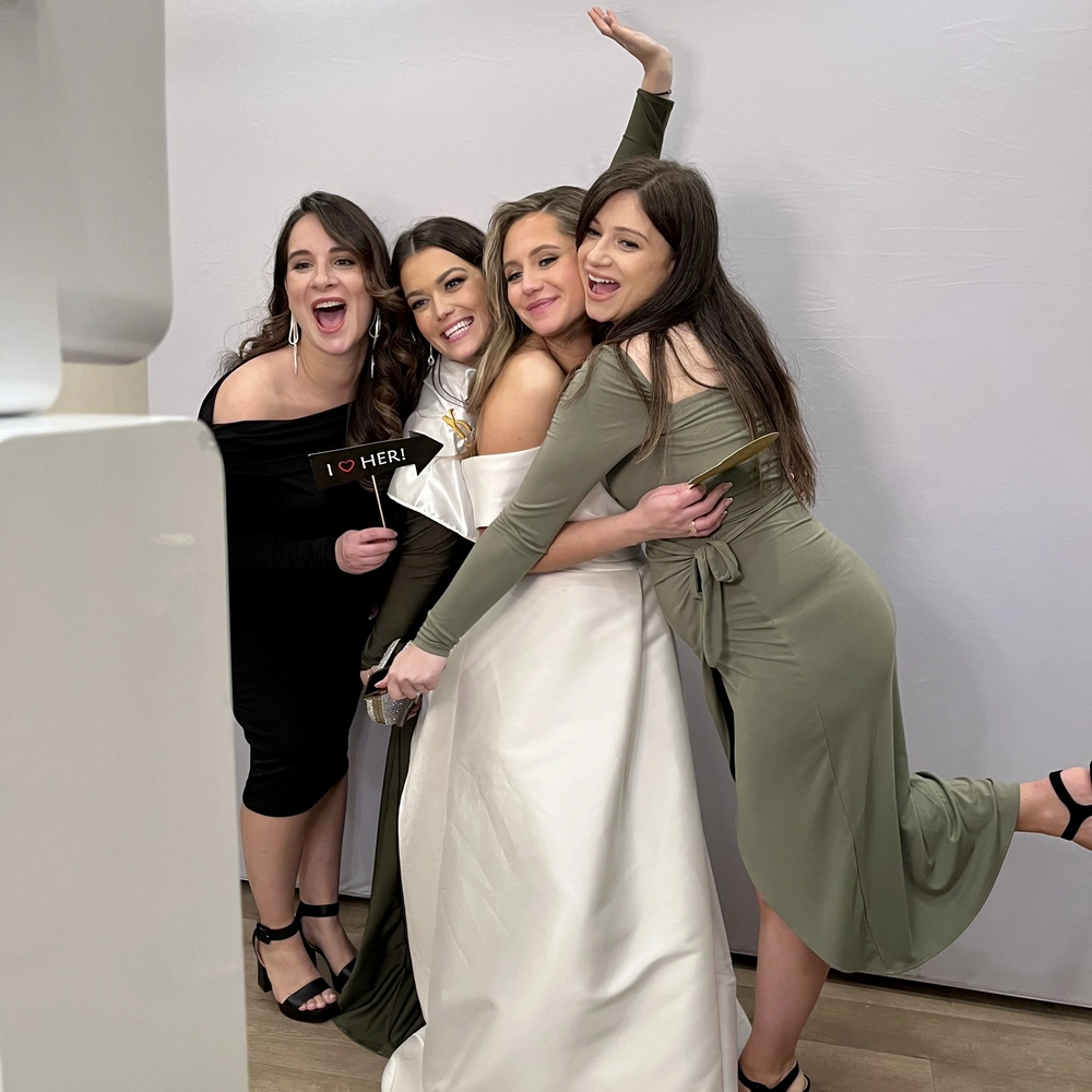 Group of women posing for a photo booth at a wedding